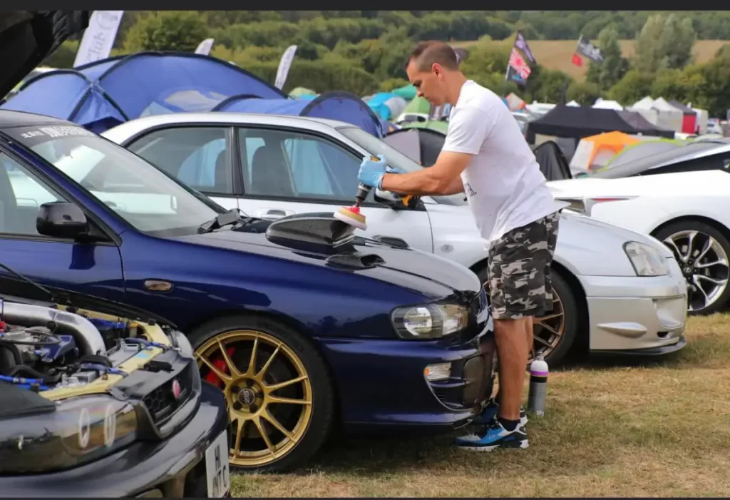 A photo showing Eddy Potts at a cat detailing event shining up a car. This shows how good EP Detailer is.